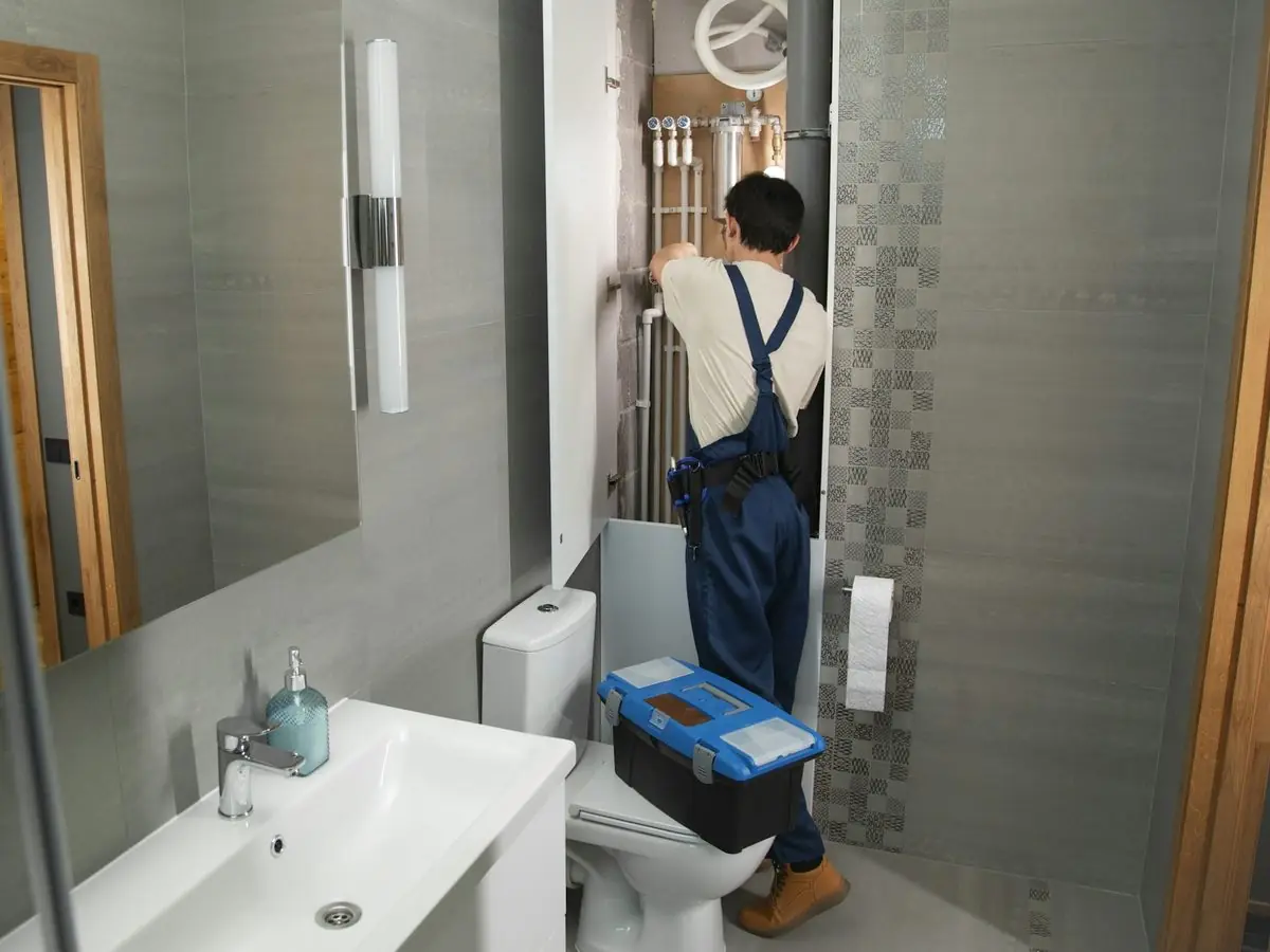 Plumber with a toolbox in a bathroom