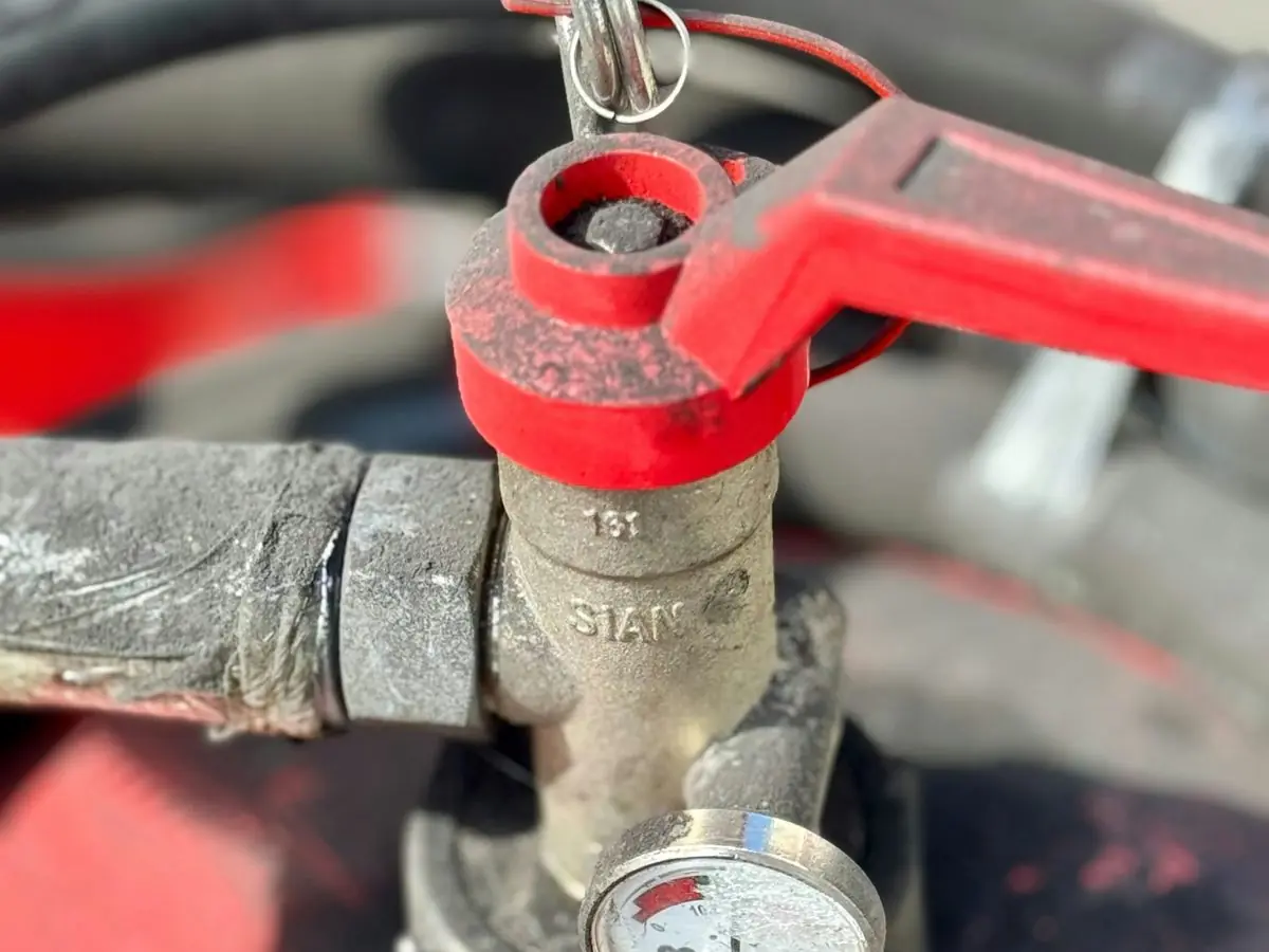 Red-handled valve and pressure gauge on a water line