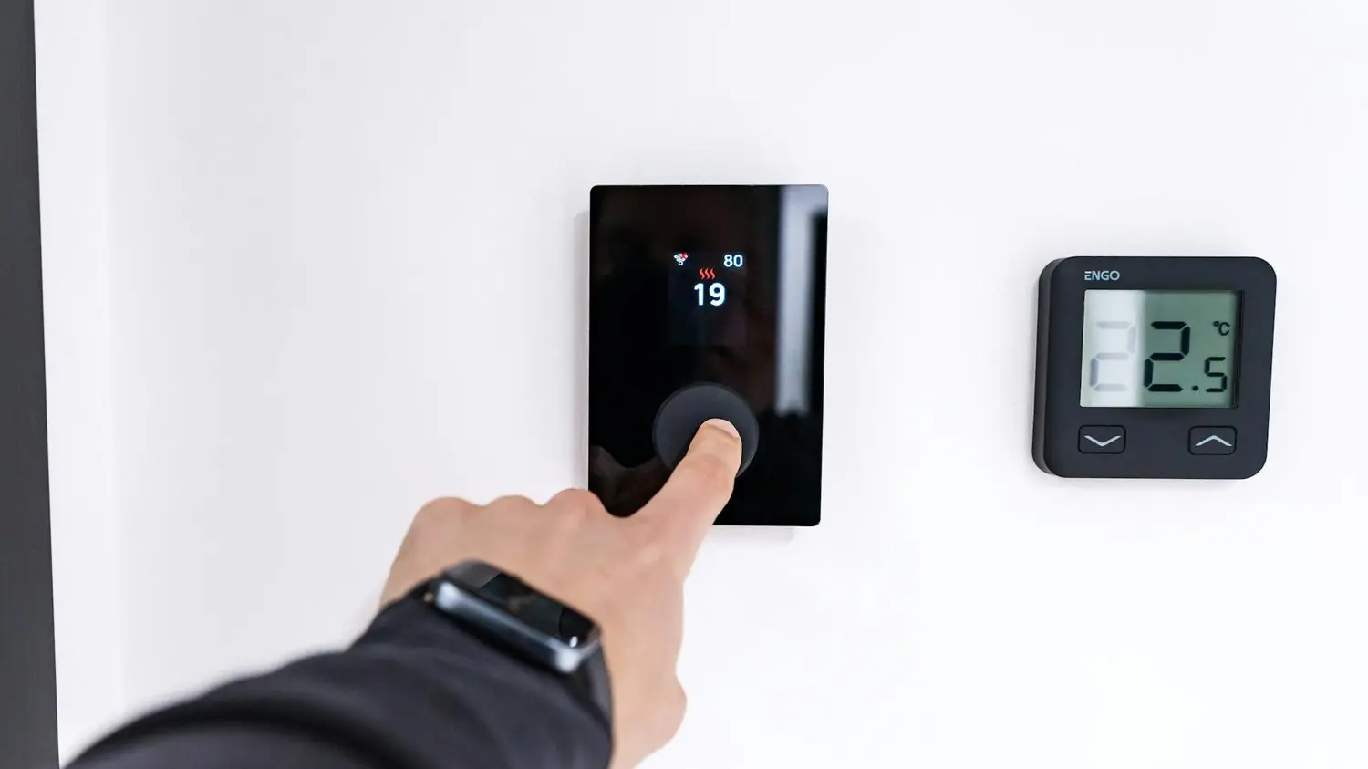 Finger pressing a digital temperature control